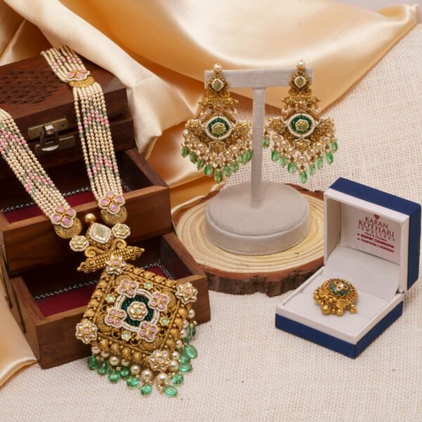 Exquisite Indian jewelry set featuring a necklace, earrings, and ring adorned with intricate designs and colorful gems.